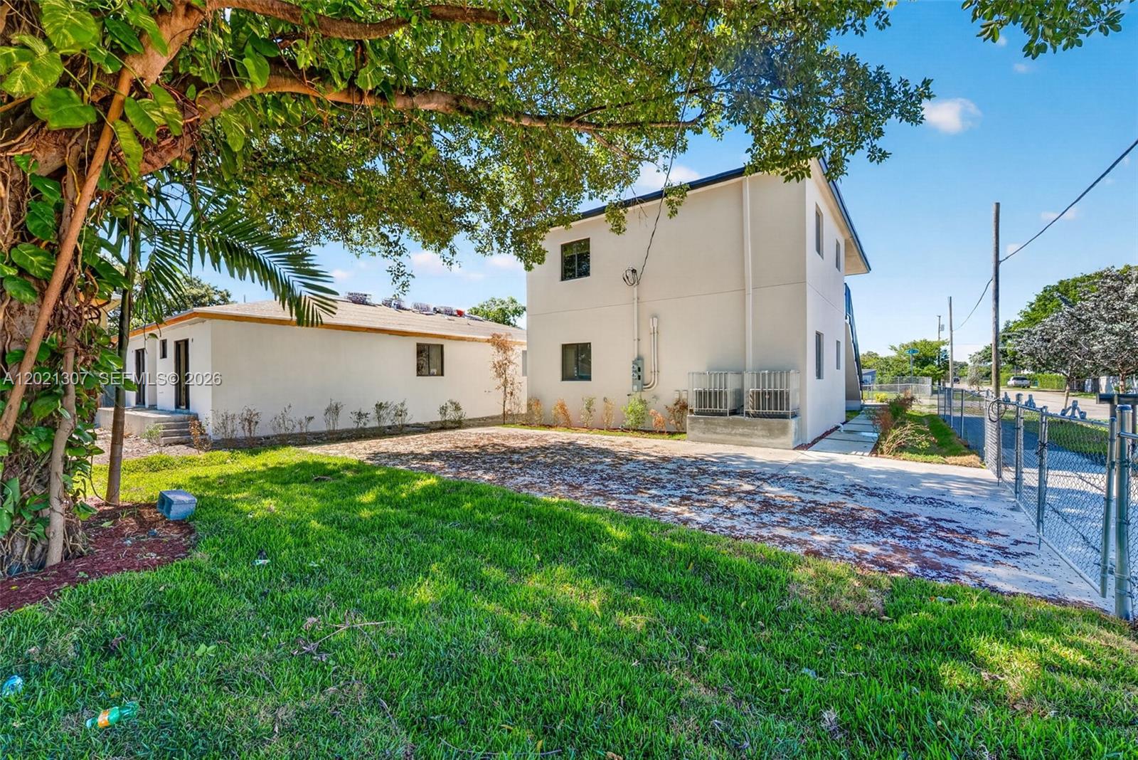 A two-story white building stands next to a single-story structure with a paved driveway — 1895 NW 47th Ter, Miami FL 33142, MIAMI, FL