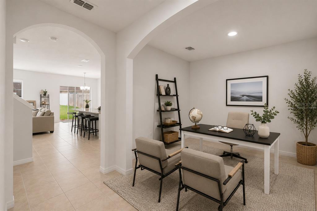 A home office with a desk, two chairs, and a bookshelf opens to a living area — 5125 FIDDLEWOOD WAY, ST CLOUD, FL