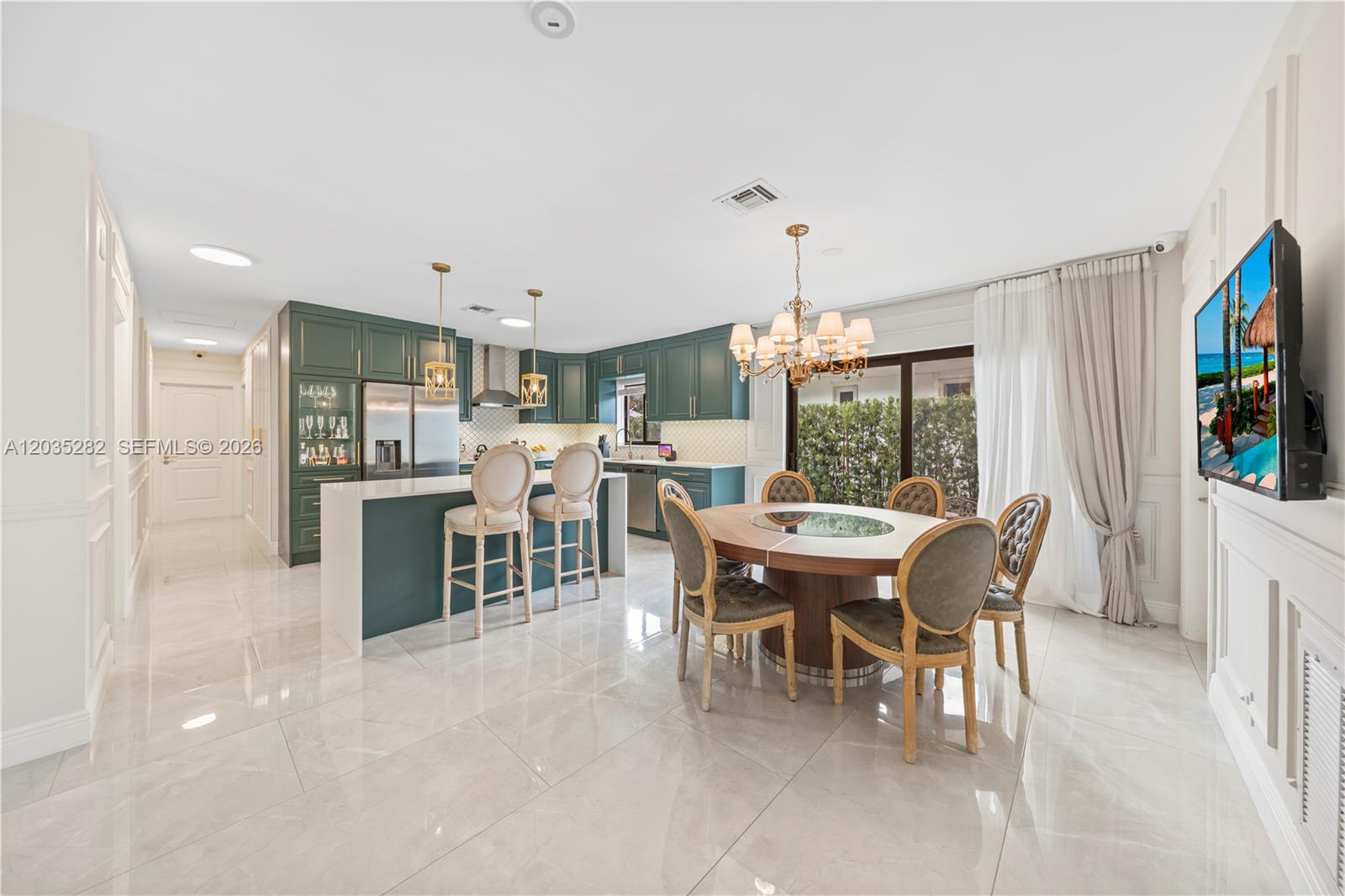 A kitchen and dining area with dark green cabinets, a central island, and tile flooring — 1302 Fillmore St, Hollywood FL 33019, HOLLYWOOD, FL