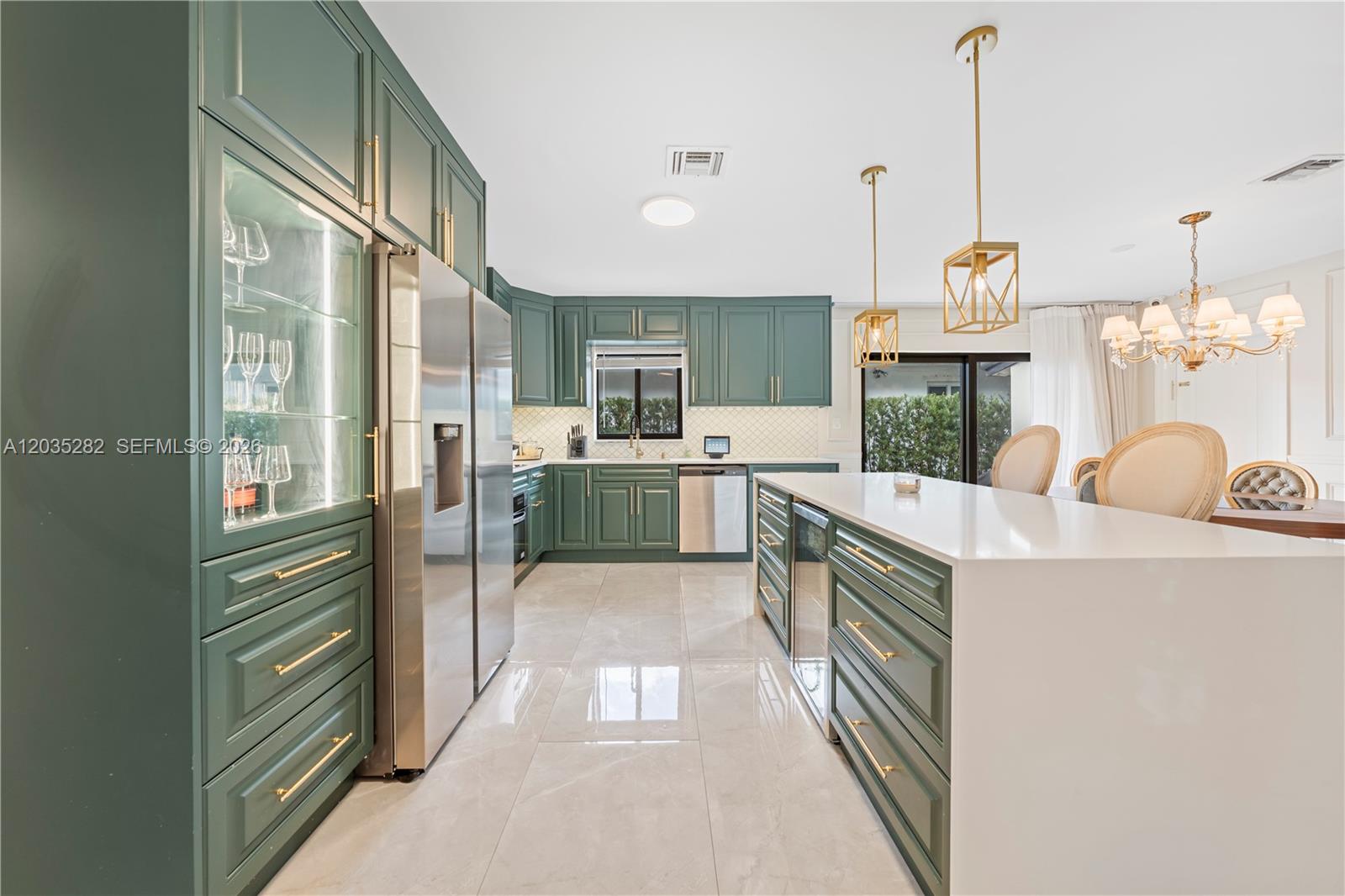 A kitchen features green cabinets, a white island, stainless steel appliances, and gold light fixtures — 1302 Fillmore St, Hollywood FL 33019, HOLLYWOOD, FL