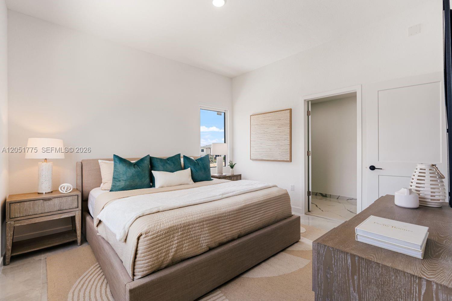 A bedroom features a beige upholstered bed, two nightstands, and a doorway leading to a bathroom — 522 NW 14 CT, Florida City FL 33034, FLORIDA CITY, FL