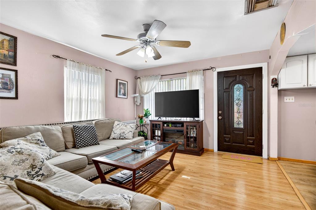 A living room features a beige sectional sofa, a wooden coffee table, and a dark front door — 1417 W YUKON STREET, TAMPA, FL