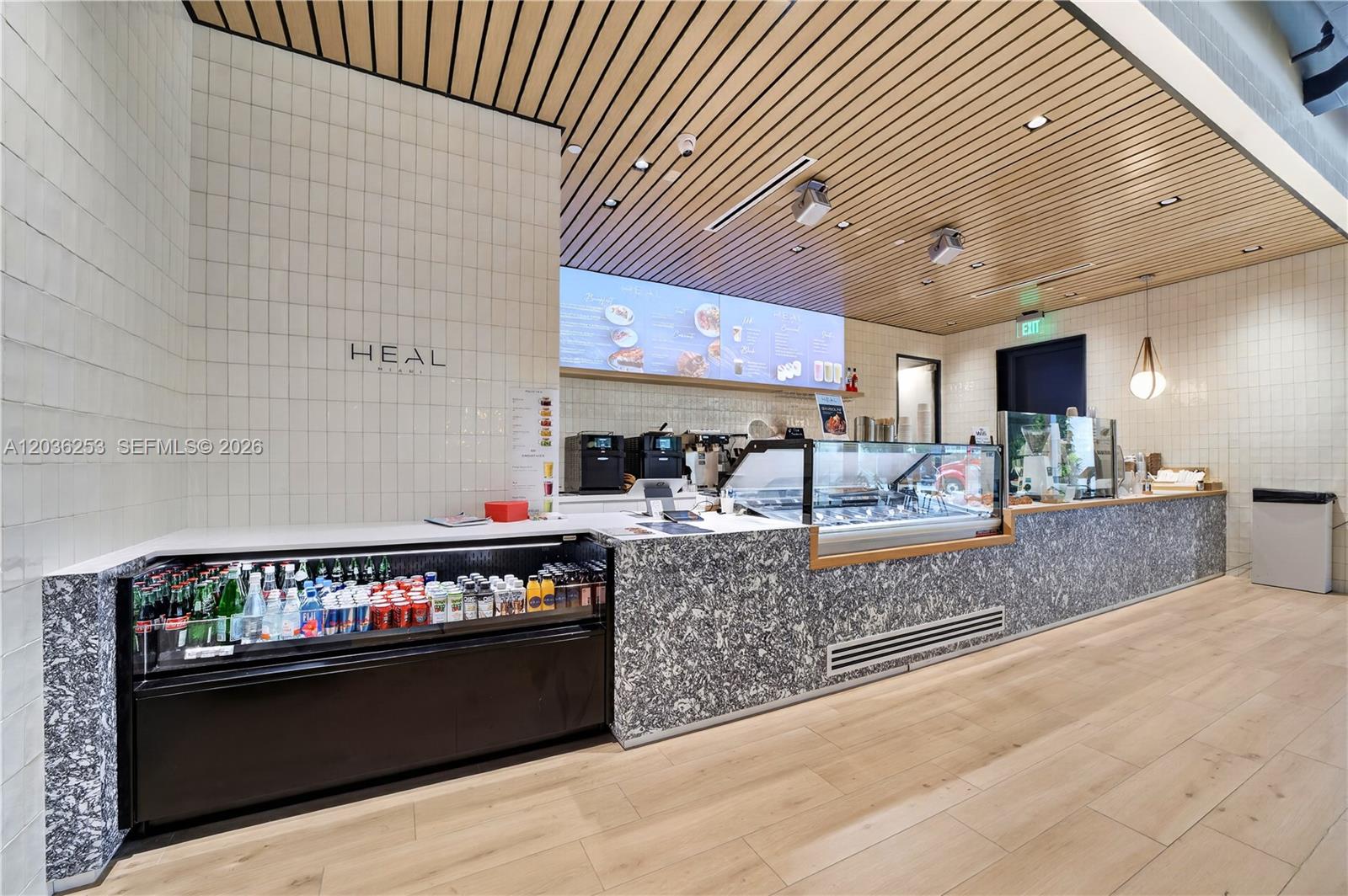 A modern cafe counter features a marble base, white tiled walls, and wood-slat ceilings — 2 S Biscayne Blvd, Miami FL 33131, MIAMI, FL