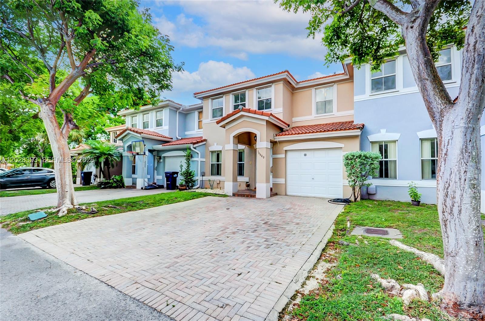 A two-story townhouse with a brick driveway, a one-car garage, and a tiled roof — 16600 SW 47th Ter, Miami FL 33185, MIAMI, FL