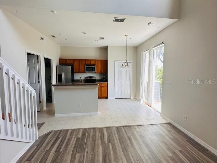 An open-concept kitchen features wood cabinets, a breakfast bar, and tile flooring — 6114 CHAPLEDALE DRIVE, ORLANDO, FL