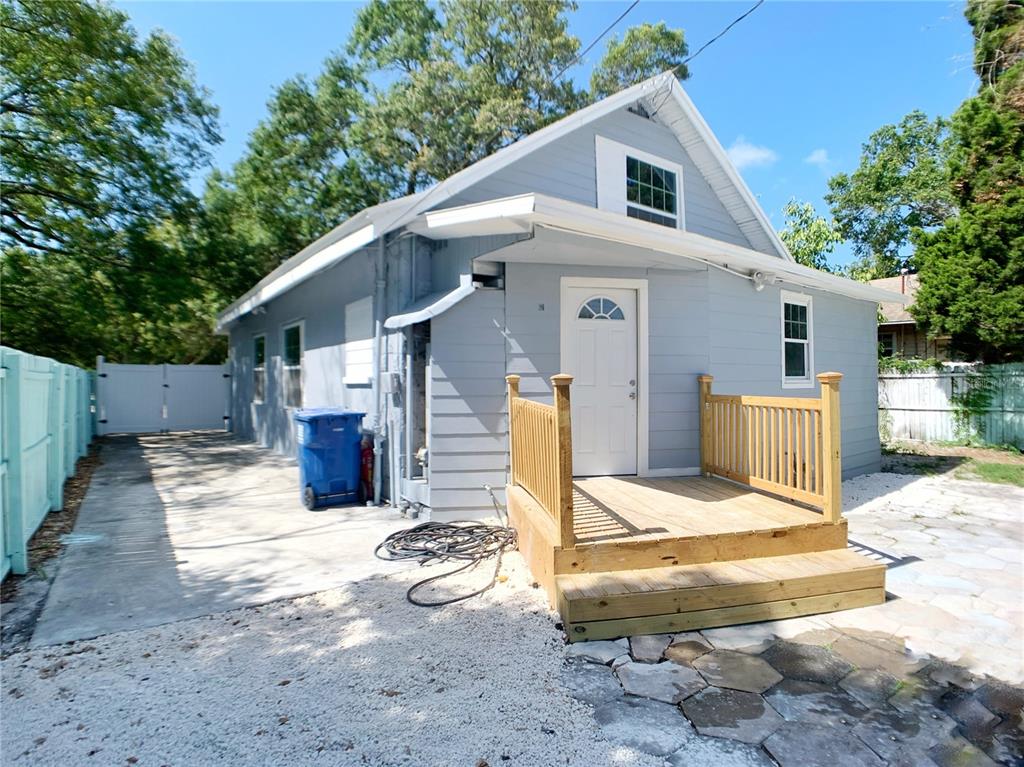 A kitchen island with a granite countertop sits on white marble-look tile flooring — 3427 16TH AVENUE S, ST PETERSBURG, FL