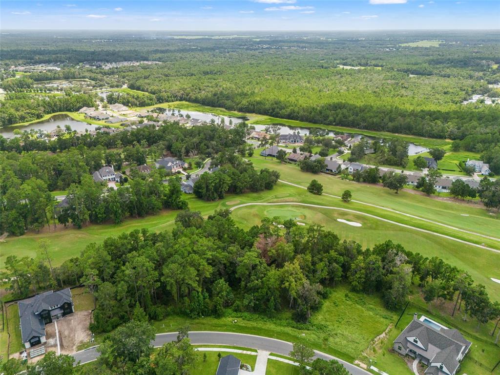 An aerial view shows a residential neighborhood bordering a golf course and wooded areas — 5979 CREEK RIDGE ROAD, BROOKSVILLE, FL
