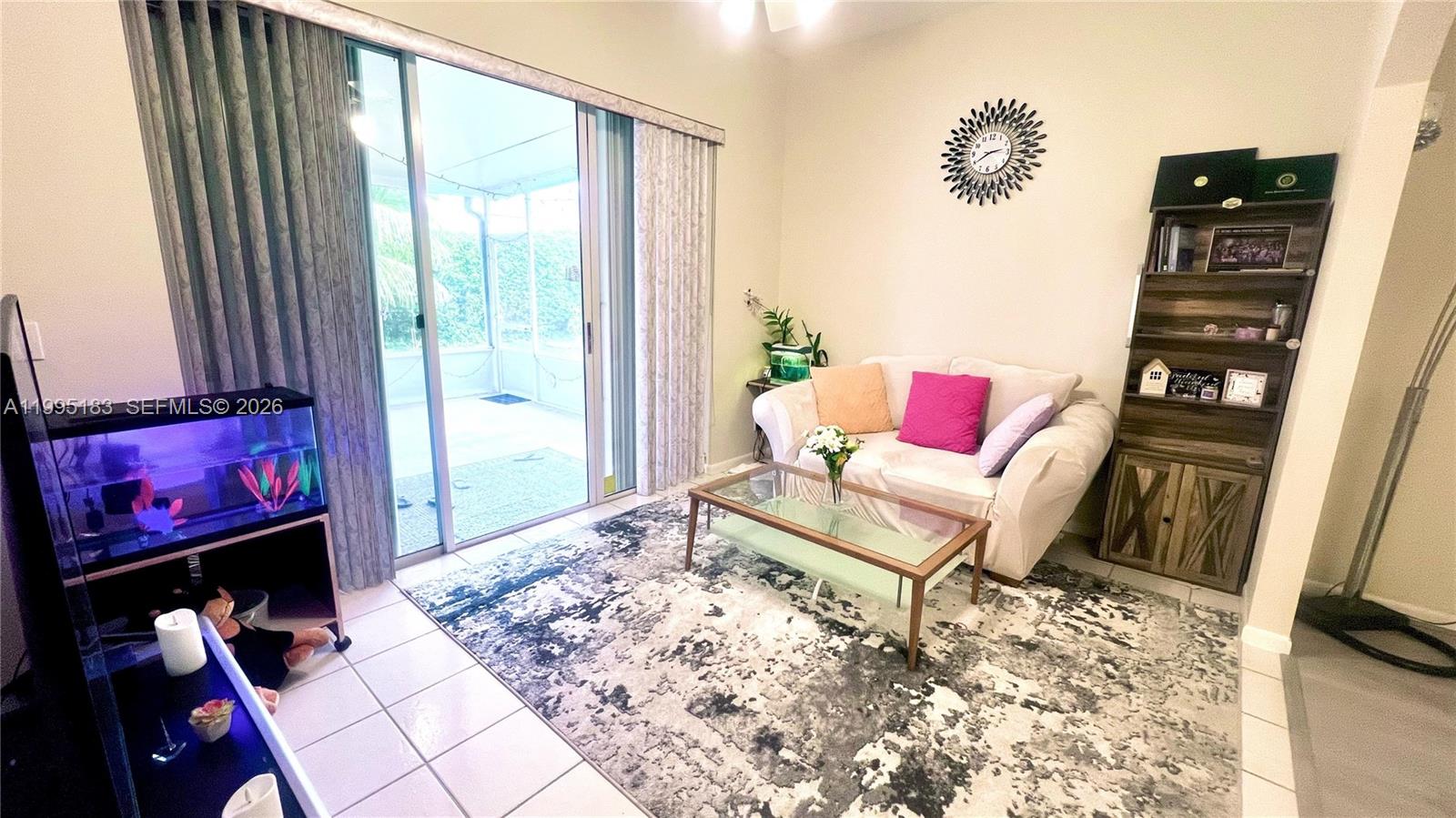 A living room features a white sofa, glass coffee table, area rug, and sliding glass doors — 3746 Spring Crest Ct, Lake Worth FL 33467, LAKE WORTH, FL