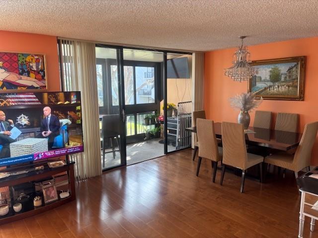 A dining and living area features orange walls, hardwood floors, a chandelier, and a balcony — 808 Bridgewood Place # 808, Boca Raton FL 33434, BOCA RATON, FL