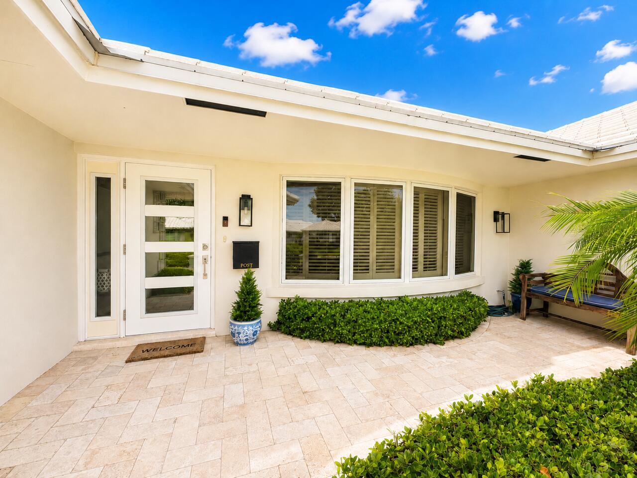 A white front door with glass panels sits on a stone patio under a roof — 1111 SW Pepperridge Terrace, Boca Raton FL 33486, BOCA RATON, FL
