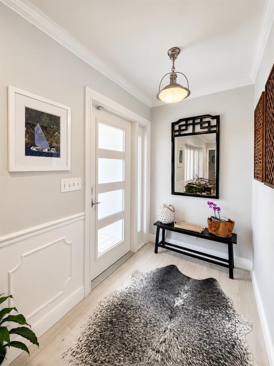 A bright entryway features a white door, a black console table, and a cowhide rug — 1111 SW Pepperridge Terrace, Boca Raton FL 33486, BOCA RATON, FL
