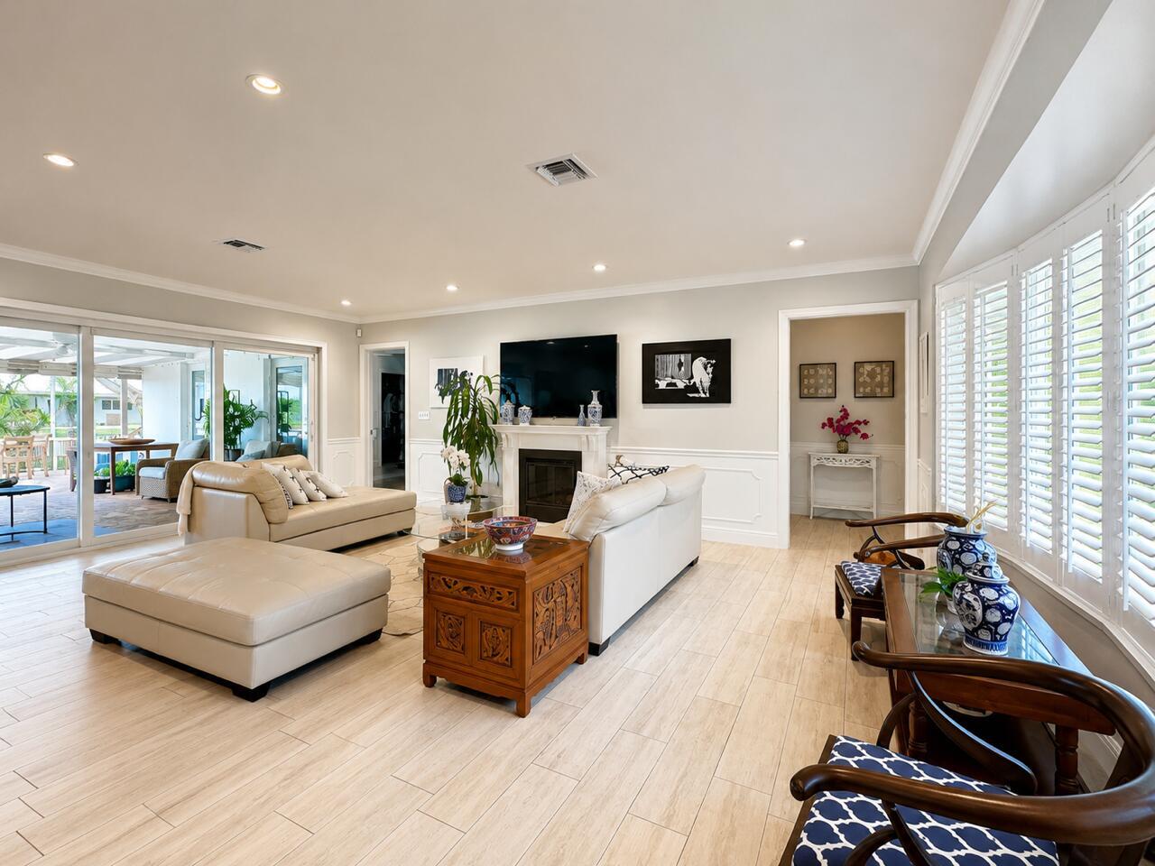A bright living room features light tile floors, a fireplace, and a view of a patio — 1111 SW Pepperridge Terrace, Boca Raton FL 33486, BOCA RATON, FL