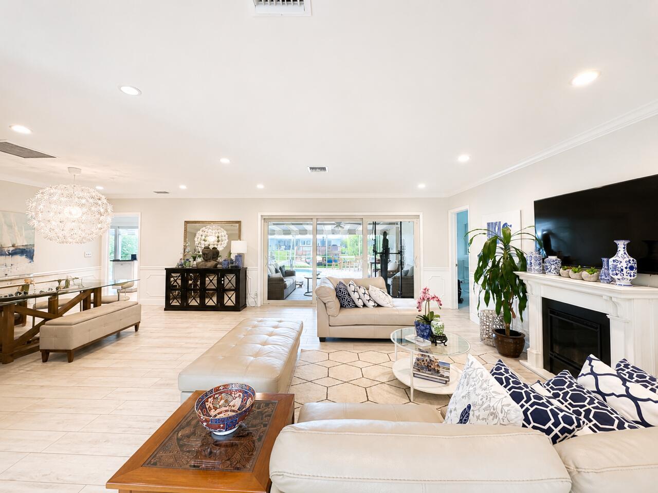 A bright, open-concept living and dining area features light tile flooring, a fireplace, and patio access — 1111 SW Pepperridge Terrace, Boca Raton FL 33486, BOCA RATON, FL