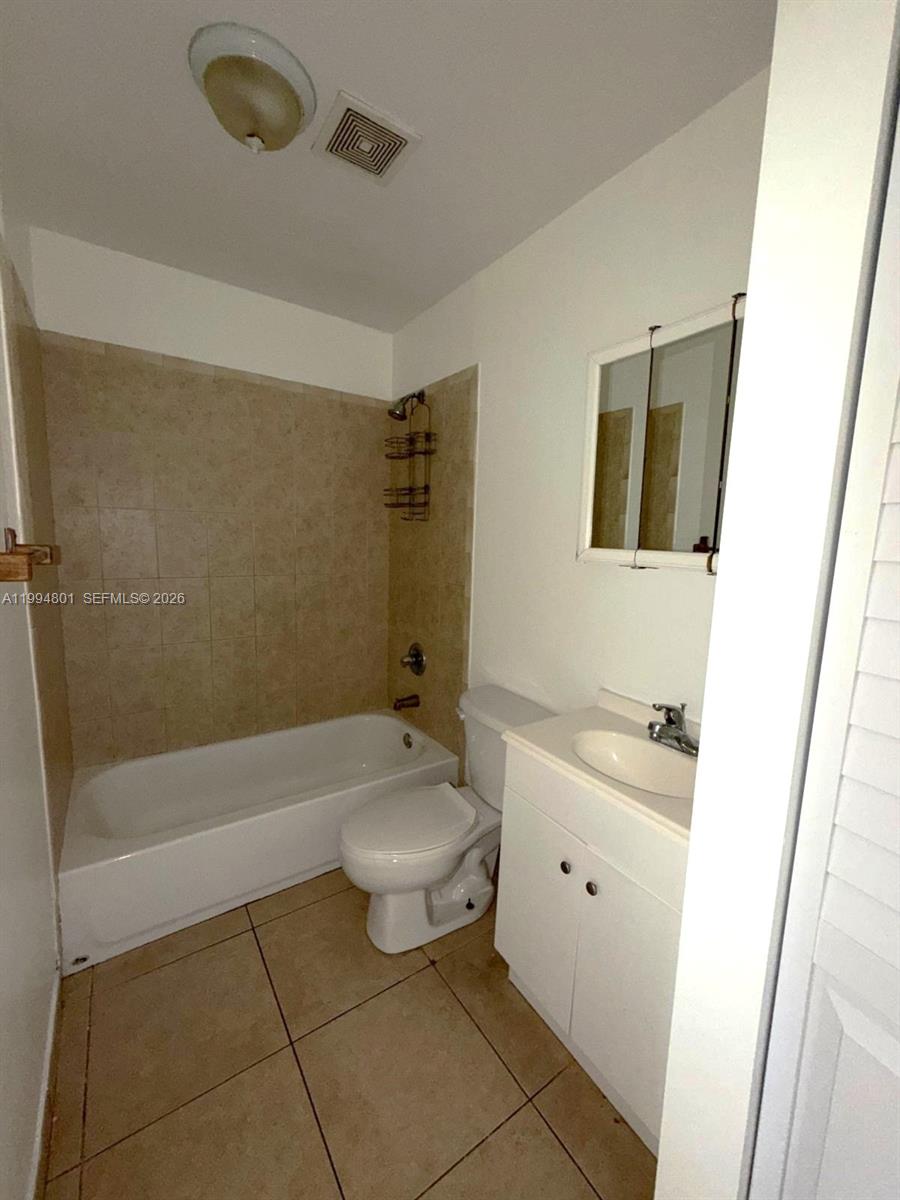 A bathroom features a tiled tub-shower combination, a white toilet, and a vanity sink — 14140 NE 2 Ct # 4, Miami FL 33161, MIAMI, FL
