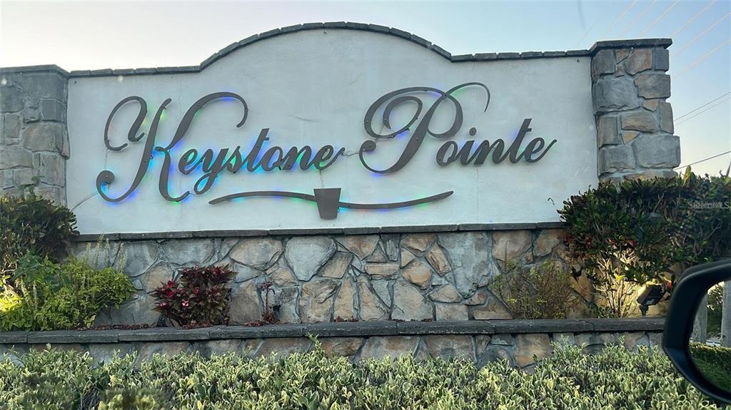 A stone-accented monument sign displays the name Keystone Pointe in a landscaped residential area — 3116 KEYSTONE POINTE COURT, ST CLOUD, FL