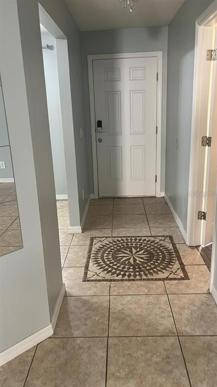 A tiled entryway features a white door with a digital lock and a decorative medallion — 3116 KEYSTONE POINTE COURT, ST CLOUD, FL