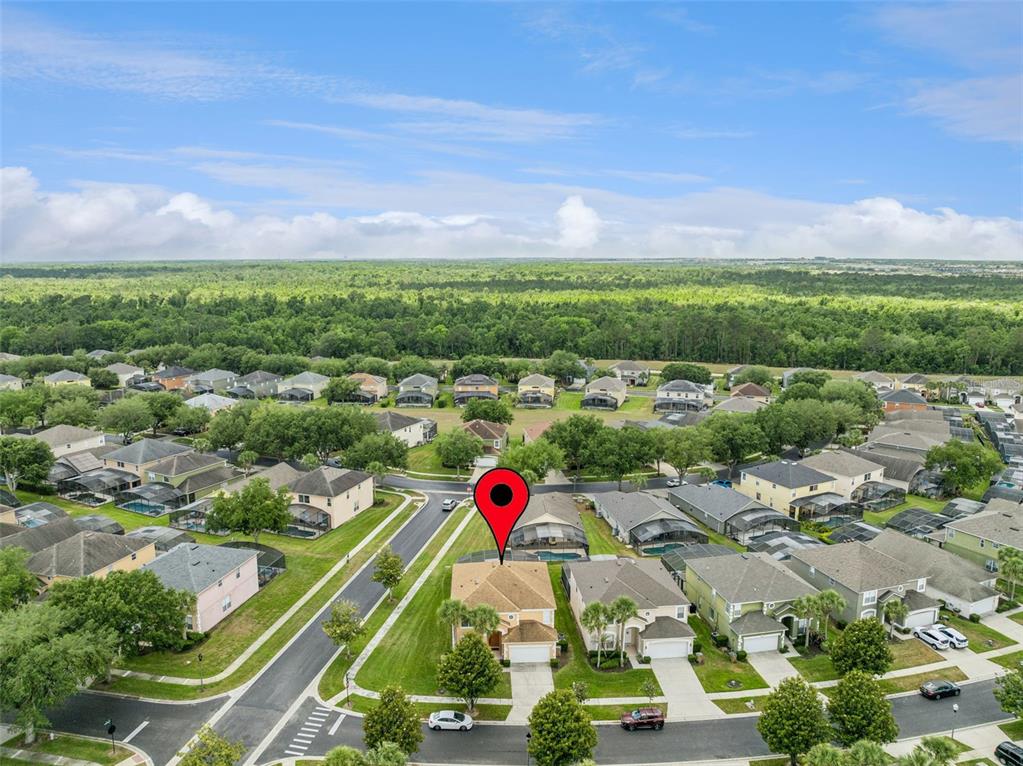 An aerial view shows a suburban neighborhood with a marked single-family home and swimming pools — 8550 SUNRISE KEY DRIVE, KISSIMMEE, FL