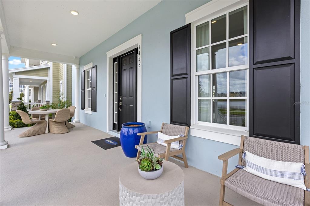 A light blue front porch features a black door, dark shutters, and outdoor seating furniture — 2511 CELEBRATION BOULEVARD, CELEBRATION, FL