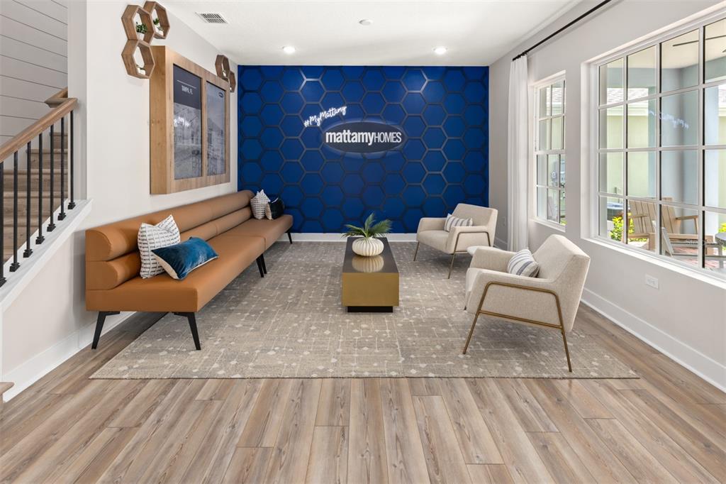A modern lobby features a blue hexagonal accent wall, a long tan sofa, and armchairs — 2511 CELEBRATION BOULEVARD, CELEBRATION, FL