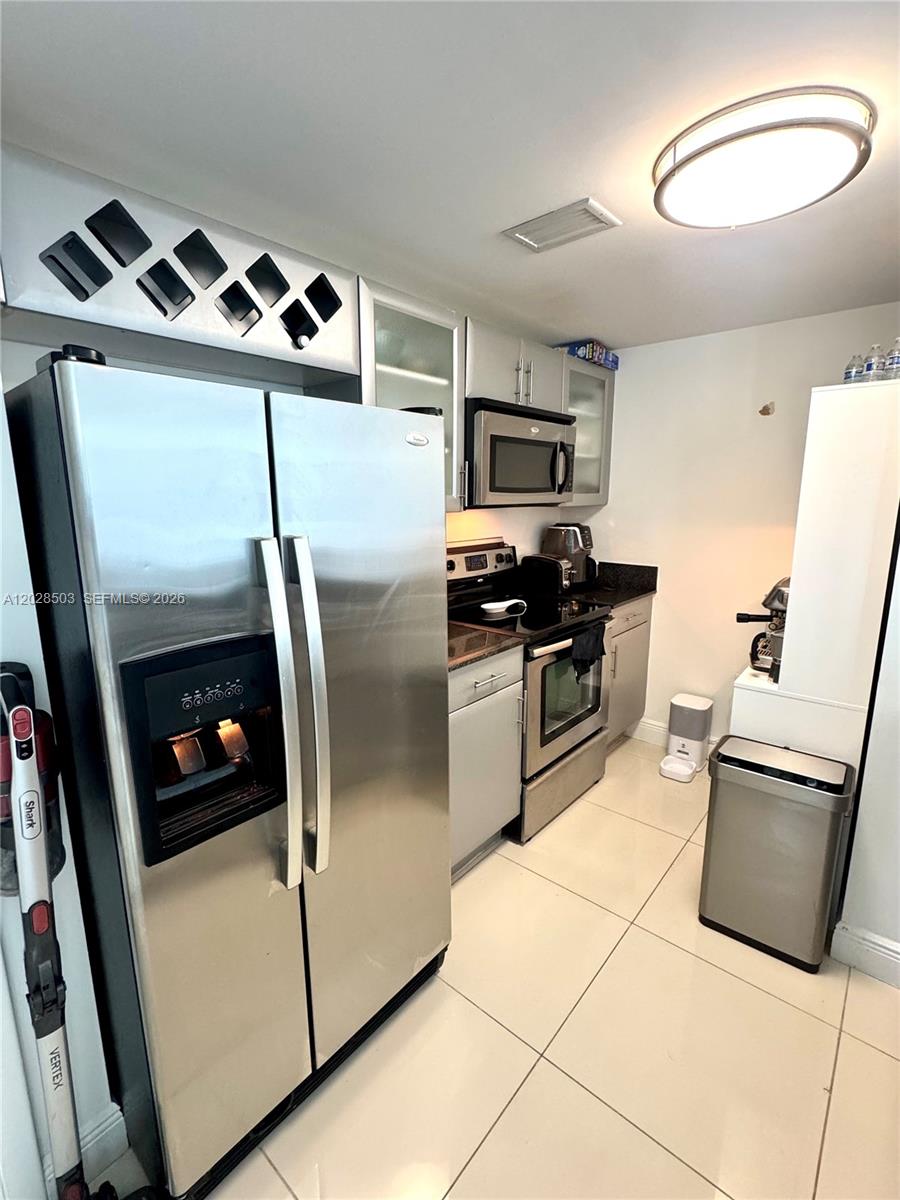 A kitchen features stainless steel appliances, light gray cabinets, and large white floor tiles — 1861 NW S River Dr # 2201, Miami FL 33125, MIAMI, FL