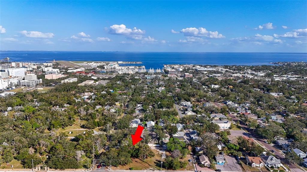 An aerial view shows a residential neighborhood with a red arrow pointing toward a lot — 1118 S DR MARTIN LUTHER KING JR STREET S, ST PETERSBURG, FL