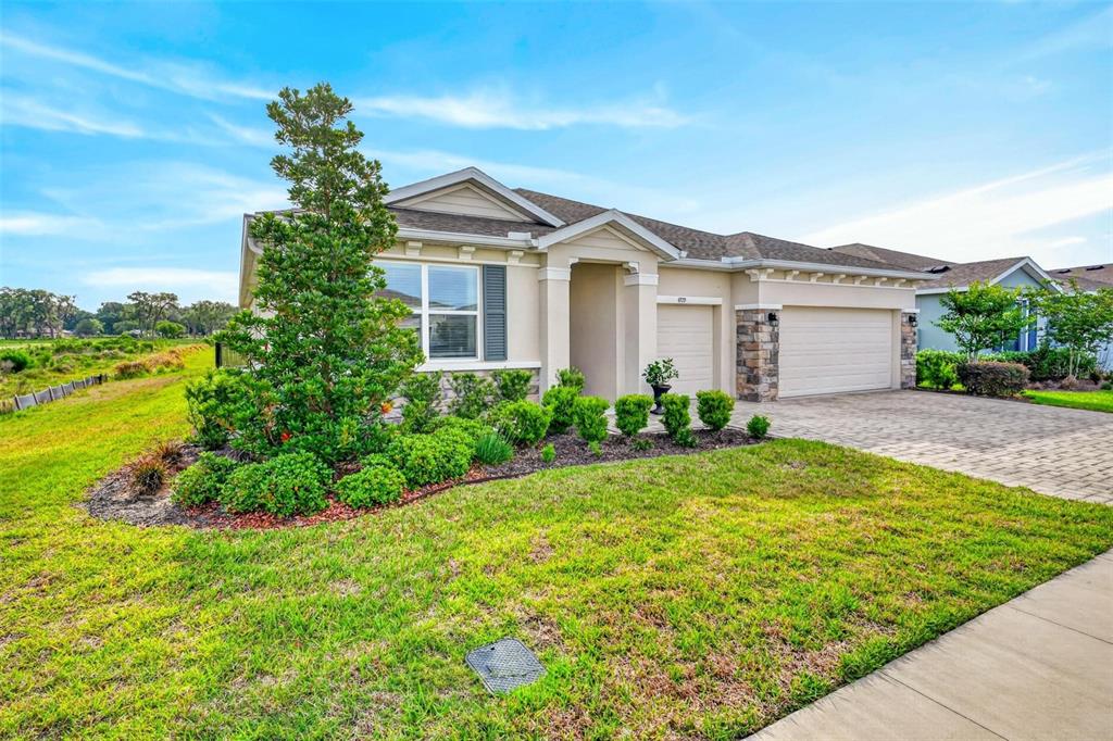 A single-story house with a stone-accented facade, a two-car garage, and a landscaped front yard — 4709 NW 51ST COURT, OCALA, FL