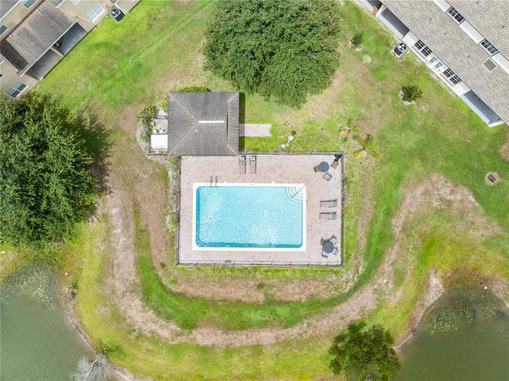 An aerial view shows a rectangular swimming pool with a patio, gazebo, and surrounding lawn — 1779 BARTON TOWNE CIRCLE, ST CLOUD, FL
