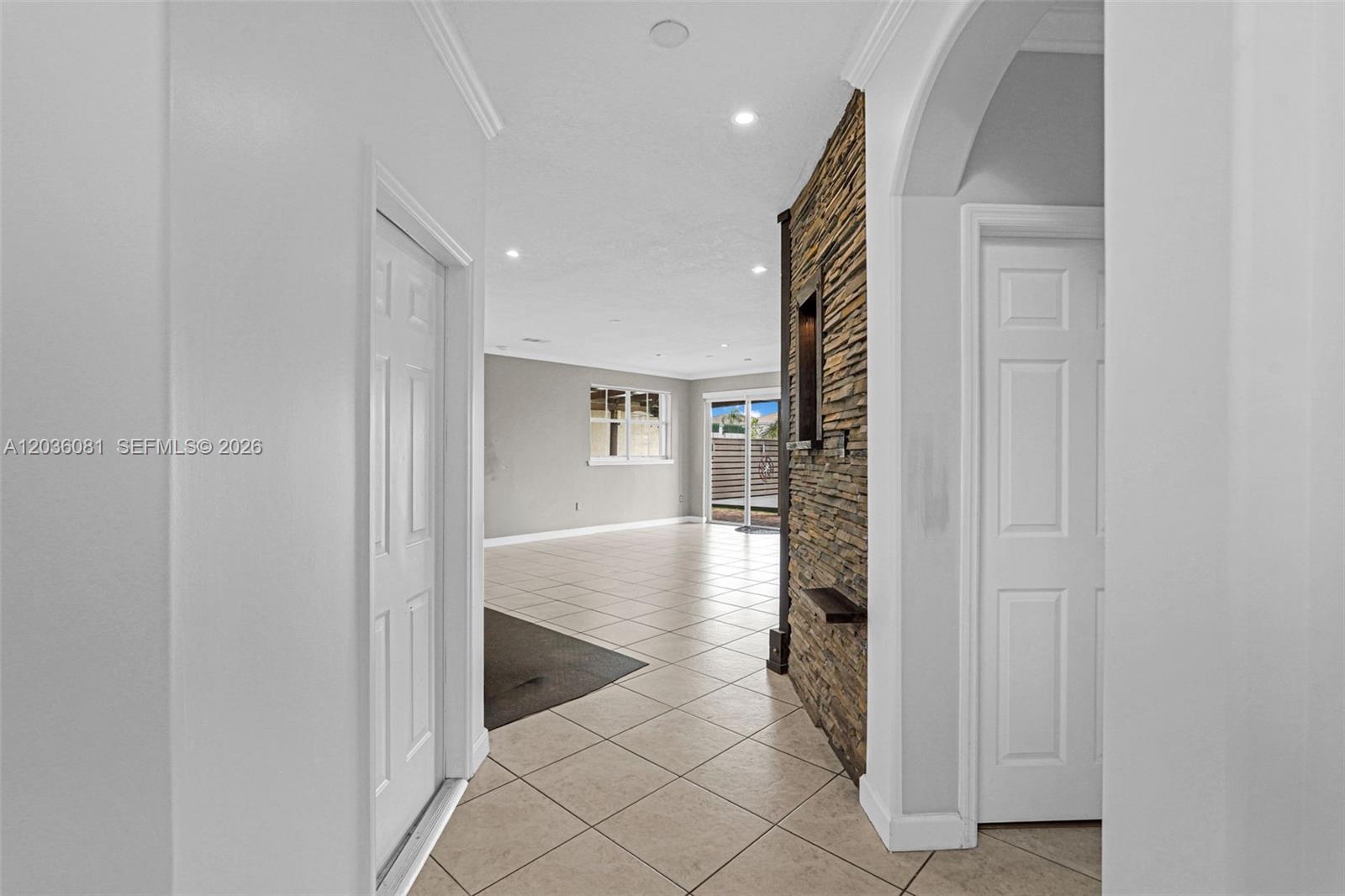 A hallway with white walls and tile flooring leads to an open living area — 11258 NW 47th Ln, Doral FL 33178, DORAL, FL