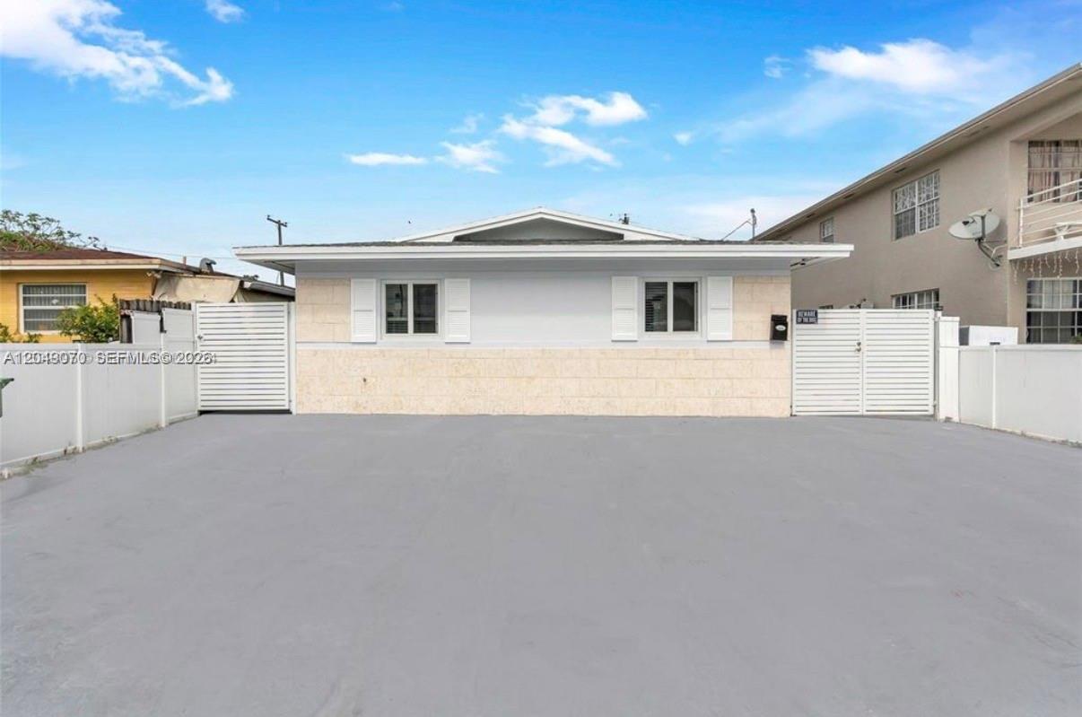 A single-story house with a light-colored stone facade and a large paved driveway — 329 W 18th St, Hialeah FL 33010, HIALEAH, FL