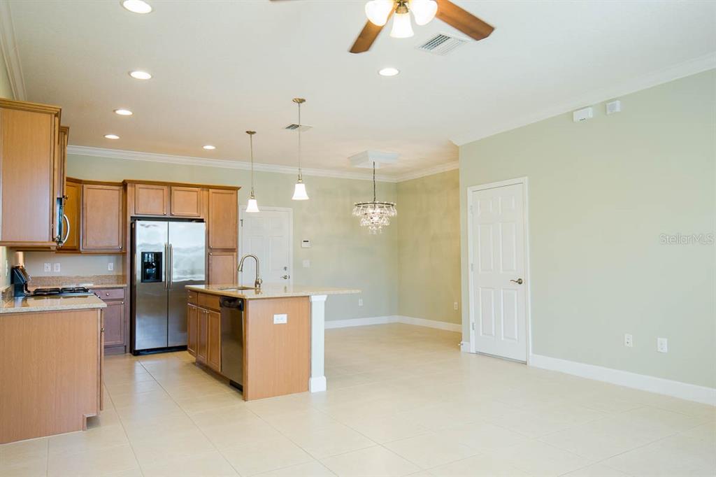 A kitchen with light wood cabinets, granite countertops, and a central island with a sink — 16856 DORMAN ROAD, LITHIA, FL