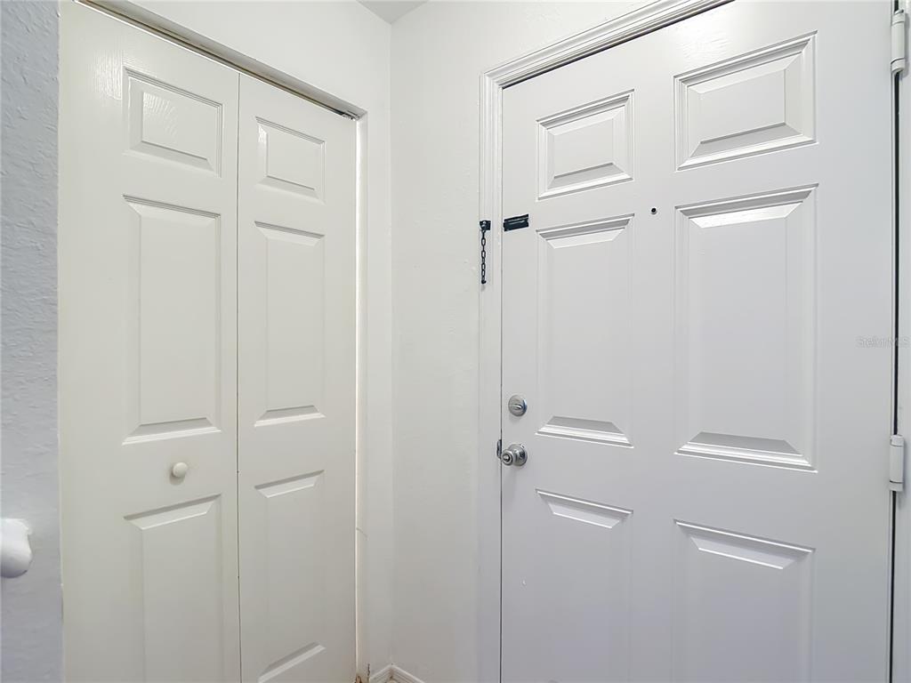 A white interior door and a white bifold closet door are set against white walls — 36106 LAKE CHASE BOULEVARD Unit 201, ZEPHYRHILLS, FL