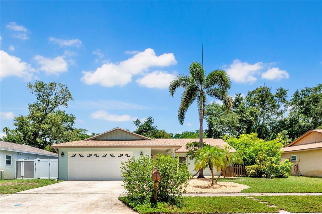 A single-story house with a white garage, a palm tree, and a green lawn — 11775 112TH AVENUE, SEMINOLE, FL