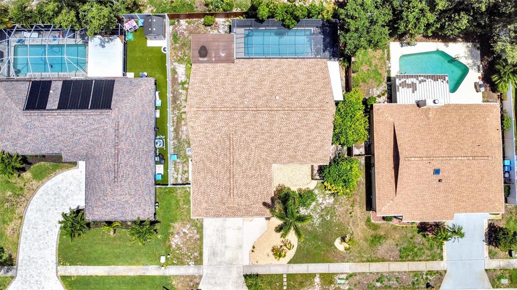 An aerial view shows three suburban houses with swimming pools and driveways in a neighborhood — 11775 112TH AVENUE, SEMINOLE, FL