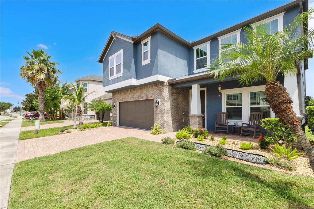 A two-story blue house with a stone facade, a two-car garage, and a front porch — 5233 VILLA ROSA AVENUE, ST CLOUD, FL