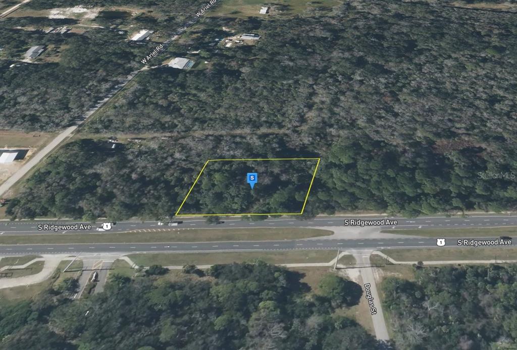 An aerial view shows a rectangular, wooded vacant lot bordering a multi-lane highway — 4670 S RIDGEWOOD AVENUE, EDGEWATER, FL