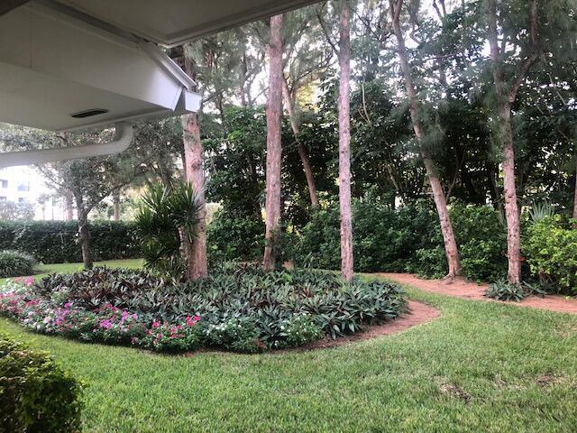 A view from a patio looking out at a landscaped garden with trees and shrubs — 1262 Sugar Sands Boulevard, West Palm Beach FL 33404, WEST PALM BEACH, FL