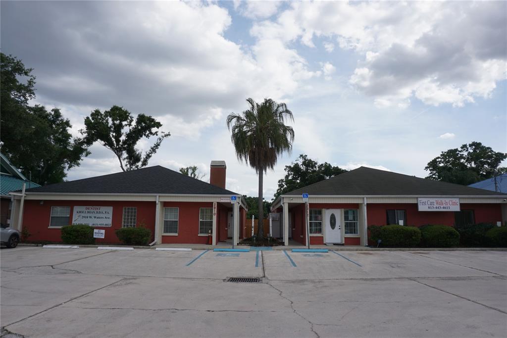 A red-painted commercial building with two separate entrances and a central palm tree — 2910 & 2912 W WATERS AVENUE, TAMPA, FL