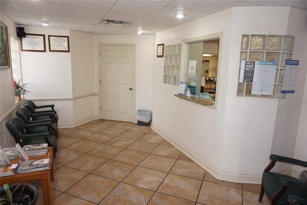 A waiting room features tile floors, a reception window, and several chairs arranged for seating — 2910 & 2912 W WATERS AVENUE, TAMPA, FL