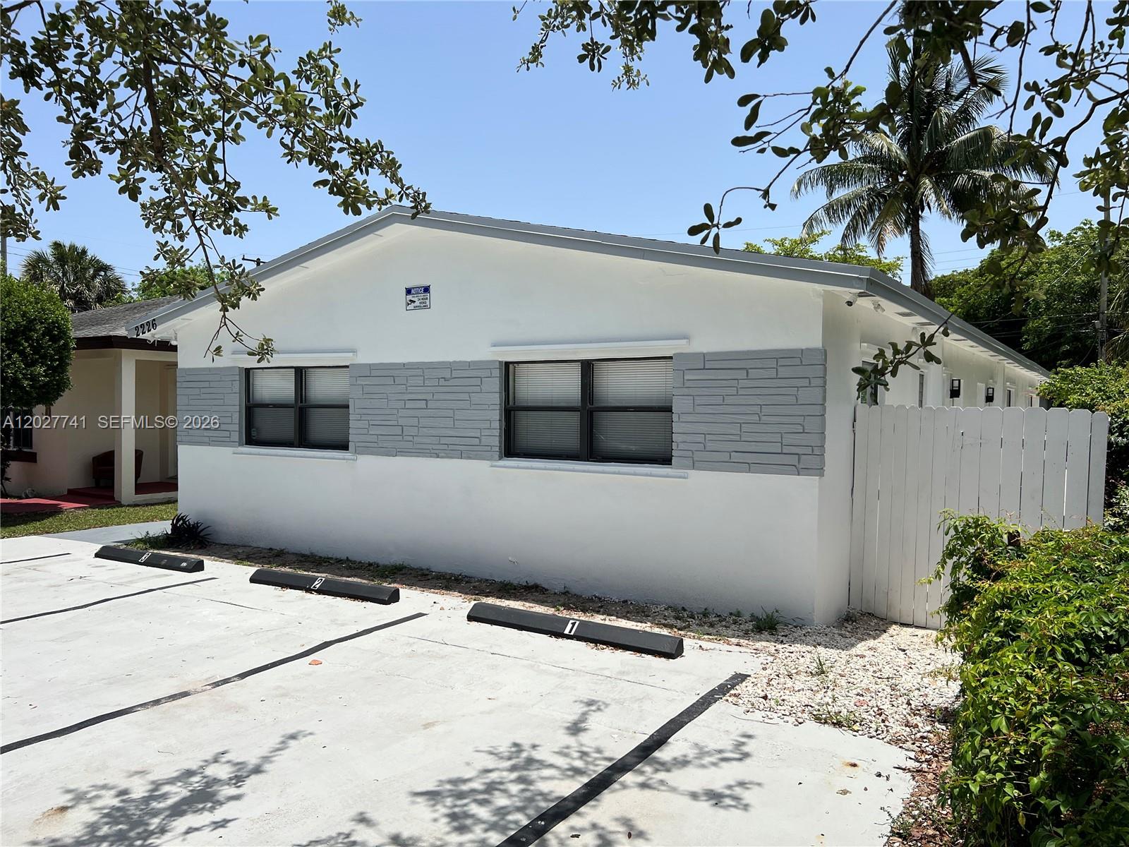 A white building with gray stone accents and numbered parking spaces in front — 2226 Cody St, Hollywood FL 33020, HOLLYWOOD, FL