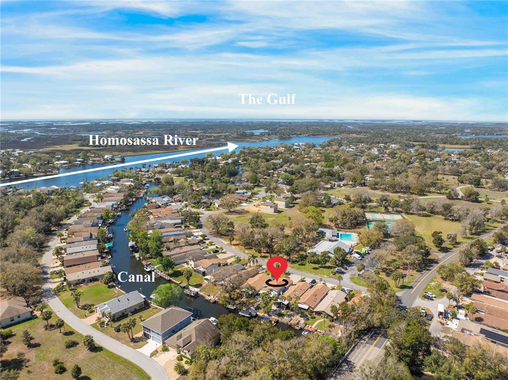 An aerial view shows a residential neighborhood with a canal leading to the Homosassa River — 11436 W CLUBVIEW DRIVE, HOMOSASSA, FL