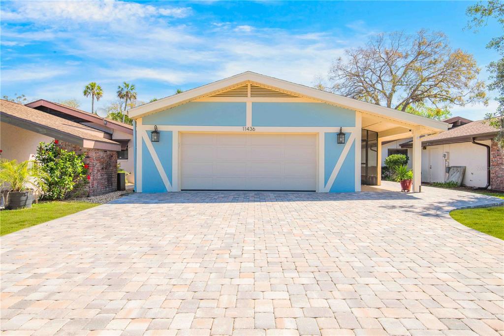 A light blue single-story house features a two-car garage and a paved driveway — 11436 W CLUBVIEW DRIVE, HOMOSASSA, FL