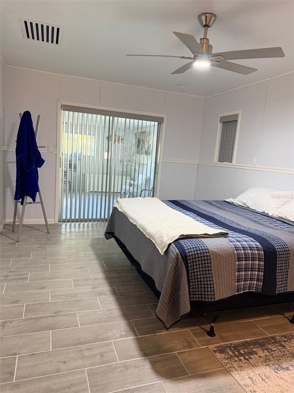 A bedroom features a bed, a ceiling fan, tile flooring, and a sliding glass door — 12 PALM DRIVE, YANKEETOWN, FL