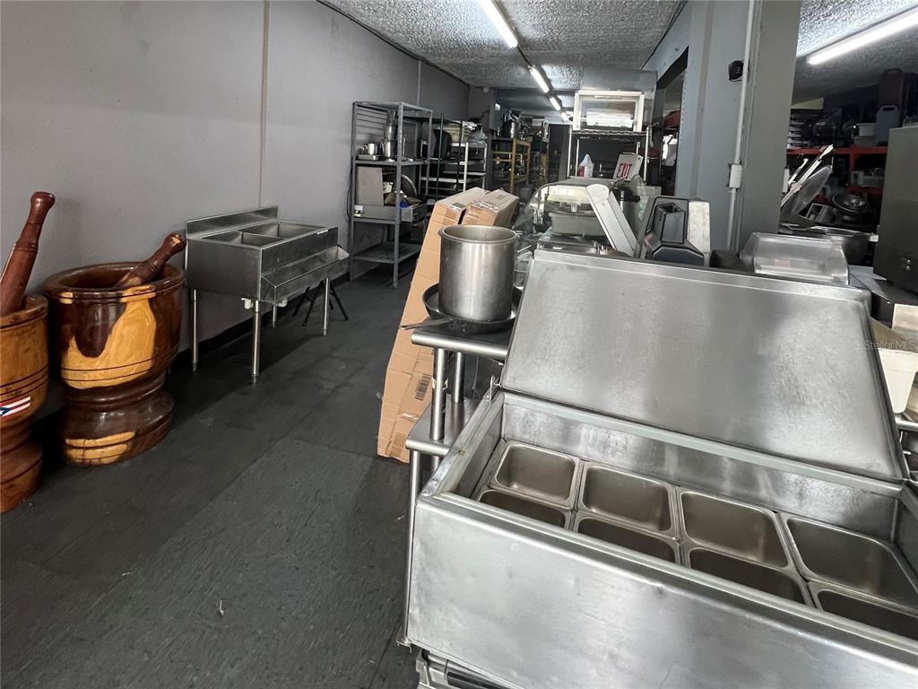 A commercial kitchen space features stainless steel prep tables, sinks, and large wooden mortars — 1328 AMERICO MIRANDA AVENUE UNIT 1328, SAN JUAN, PR
