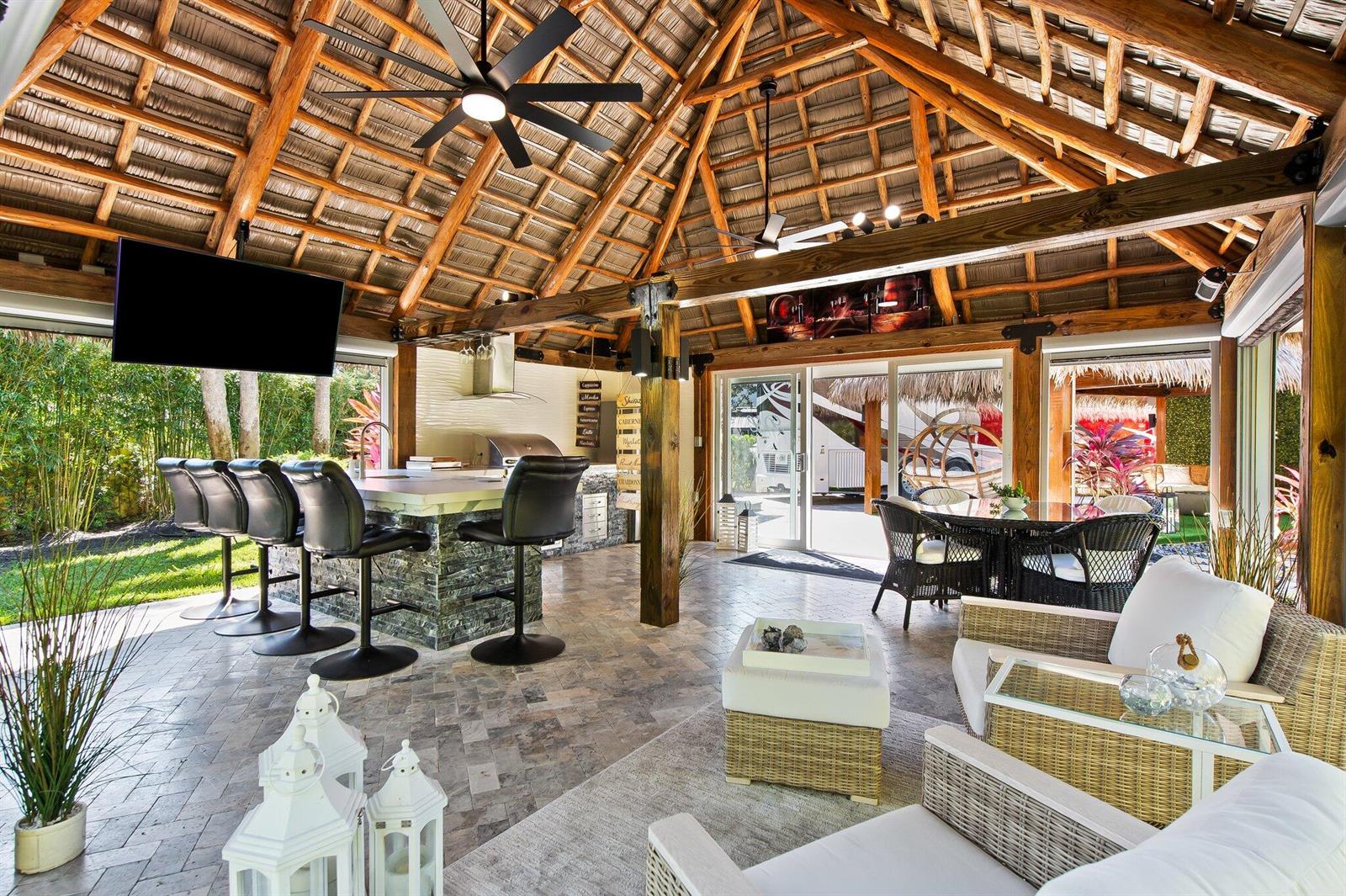 An open-air patio with a thatched roof, stone bar, dining area, and lounge seating — 110 S Cortez Drive # 110, Margate FL 33068, MARGATE, FL