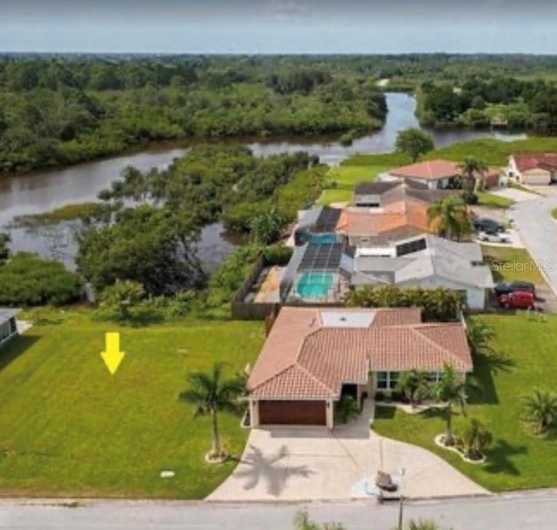 An aerial view shows a vacant grassy lot next to a house with a pool — 3982 RUDDER WAY, NEW PORT RICHEY, FL