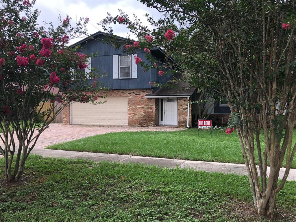 A two-story house with blue siding, a brick facade, and a two-car garage — 8413 SHADY GLEN DRIVE, ORLANDO, FL