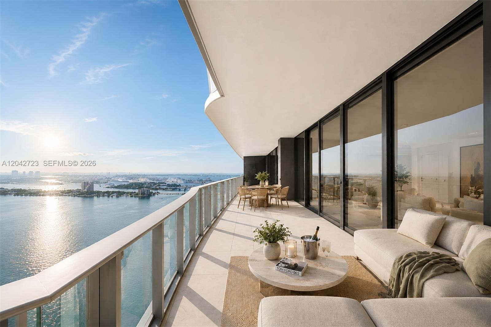 A spacious balcony features a seating area, dining set, and panoramic water views — 700 NE 24th St # 4702, Miami FL 33137, MIAMI, FL