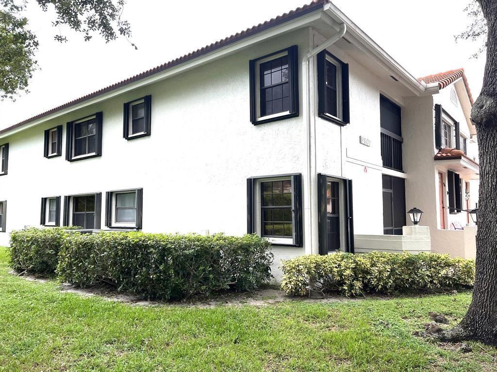 A two-story white stucco apartment building with black window frames and a landscaped hedge — 9807 Pavarotti Terrace, Boynton Beach FL 33437, BOYNTON BEACH, FL