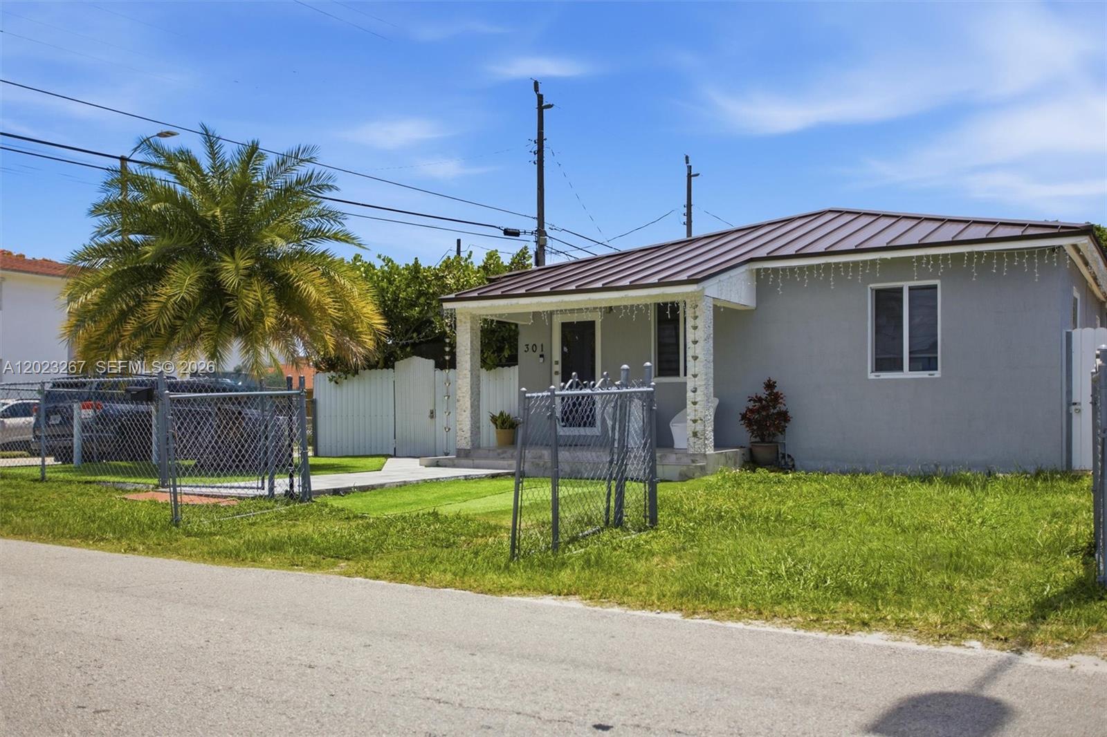 A single-story gray house with a metal roof and a chain-link fenced yard — 301 SW 36th Ave, Miami FL 33135, MIAMI, FL