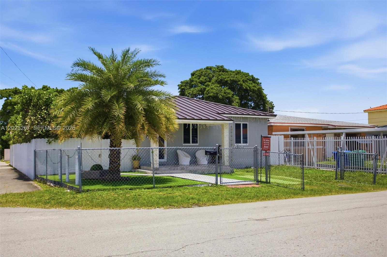 A single-story house with a metal roof and a palm tree behind a chain-link fence — 301 SW 36th Ave, Miami FL 33135, MIAMI, FL